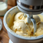 Churning thickened ice cream in an ice cream maker.